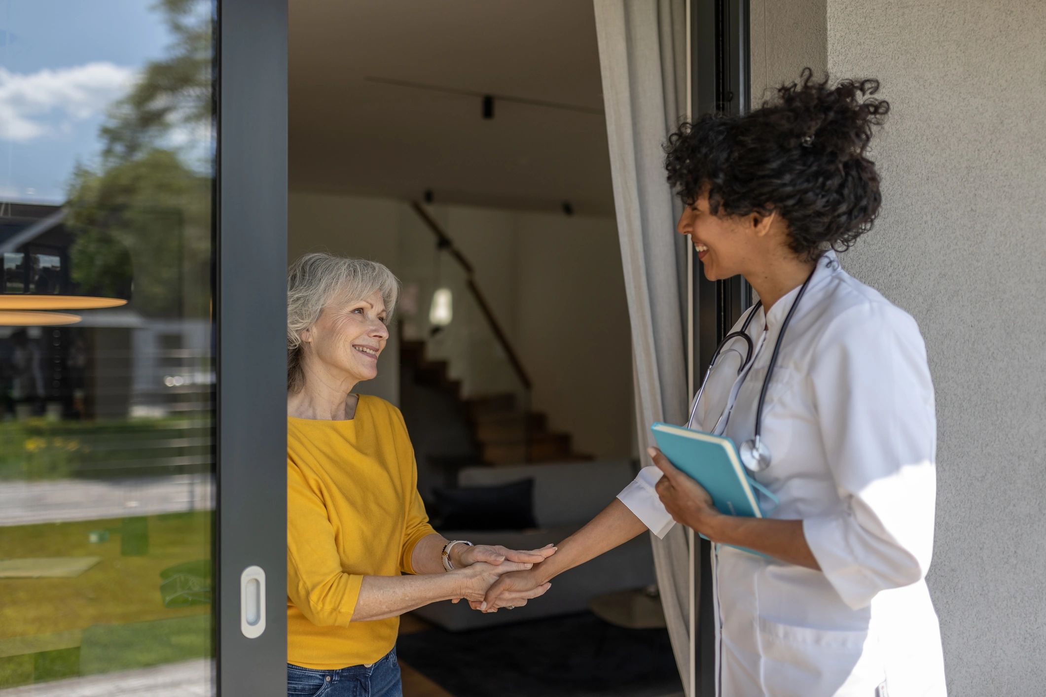 doctor and patient smiling during home visit